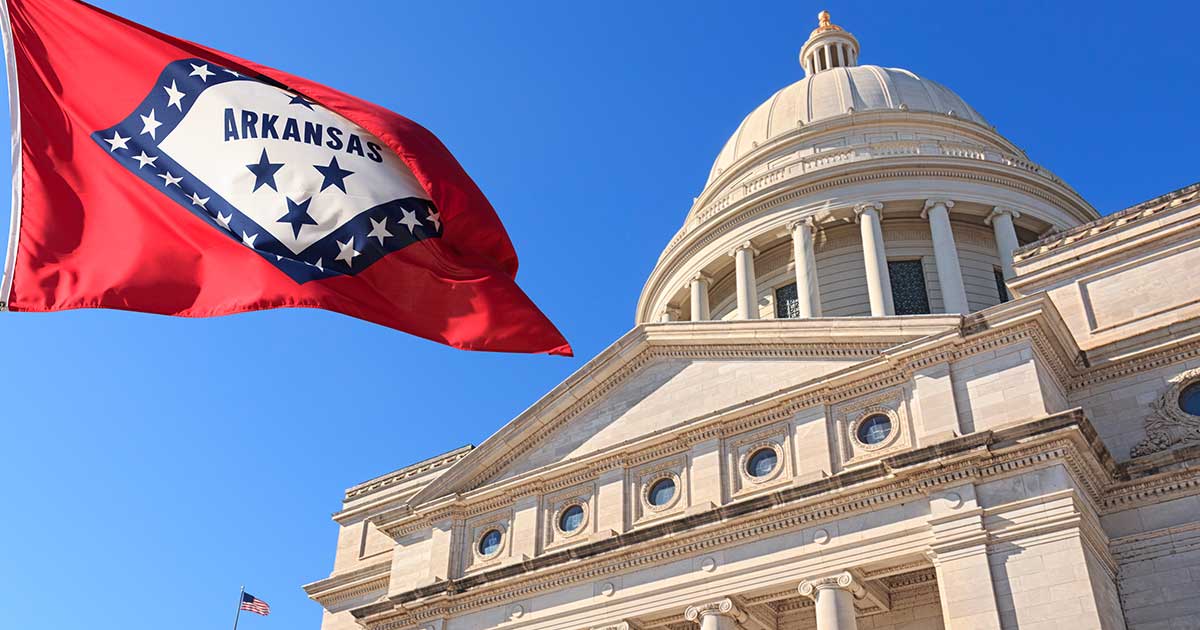 Arkansas flag in front of the capitol building