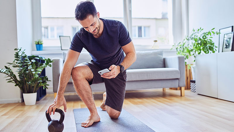 Man using a smartphone for an at-home workout.
