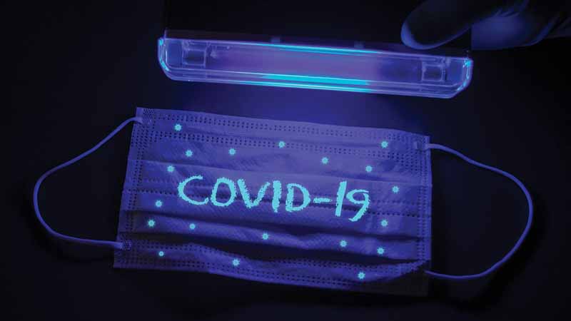 Face mask that says "COVID-19" under a black light.