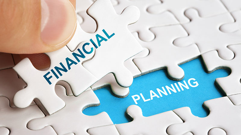 Person adding "Financial" jigsaw puzzle pieces to a "Planning" puzzle gap.