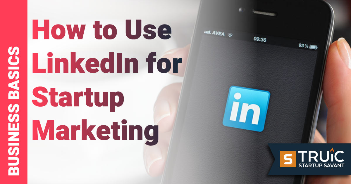 Hand holding phone showing LinkedIn icon.